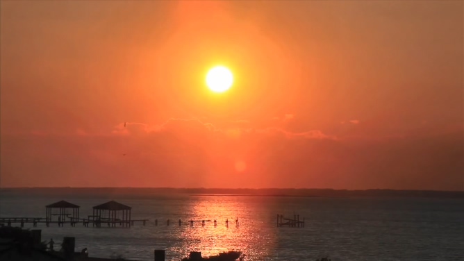 唯美梦幻的火红太阳在海平线上落下的实拍视频